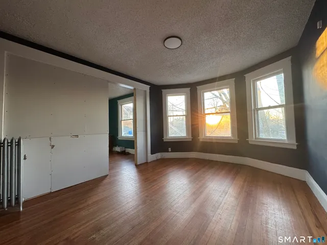 an empty room with wooden floor and windows