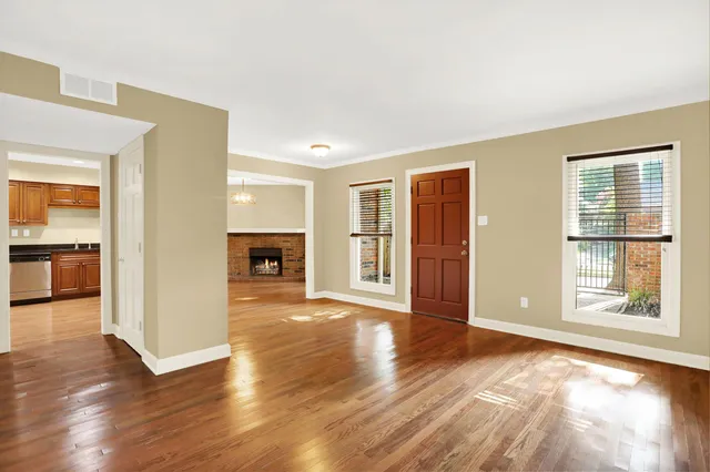a view of a livingroom with wooden floor and a kitchen space