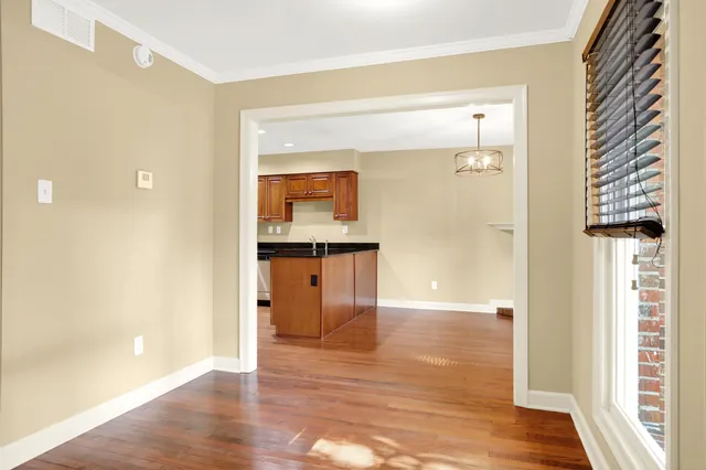 a view of empty room with wooden floor