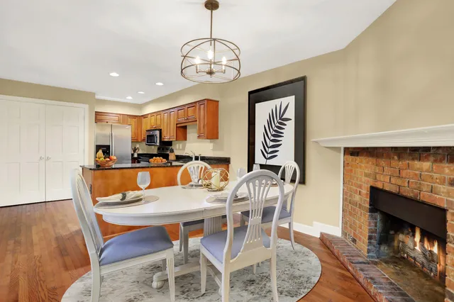 a view of a dining room with furniture wooden floor and a fireplace