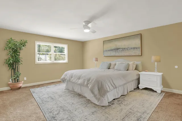 a spacious bedroom with a bed and a painting on the wall