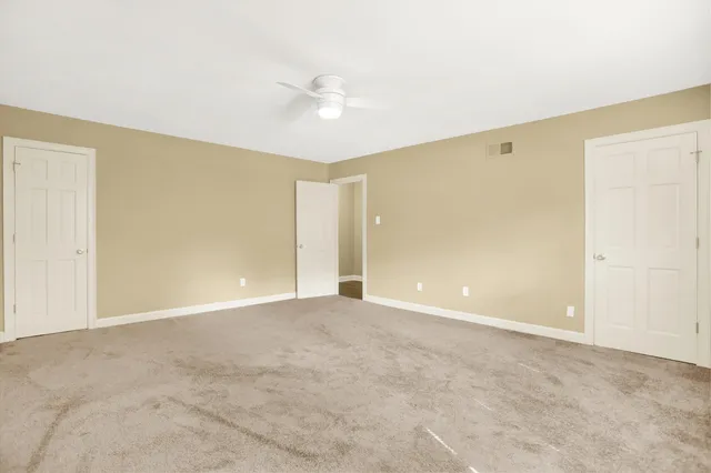 a view of an empty room with a ceiling fan
