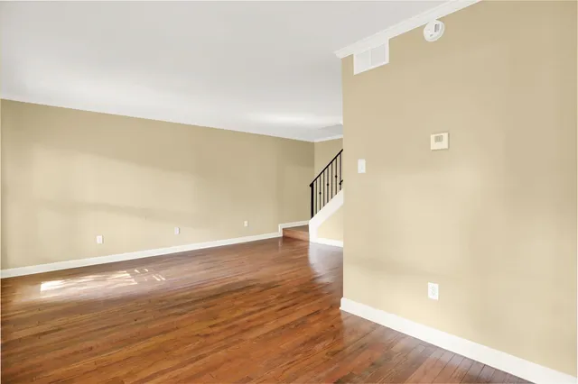 a view of a big room with wooden floor and windows