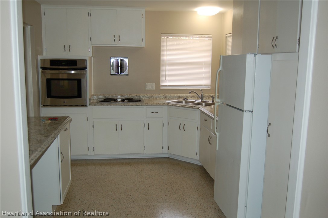 3029 West Verona Road Avon Park, FL 33825 - Photo 12 of 25 a view of cabinets a window and a refrigerator