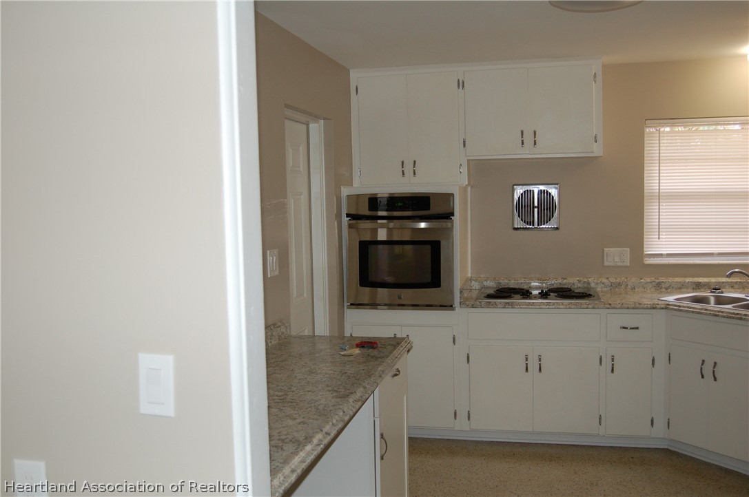 3029 West Verona Road Avon Park, FL 33825 - Photo 13 of 25 a kitchen with granite countertop white cabinets and stainless steel appliances