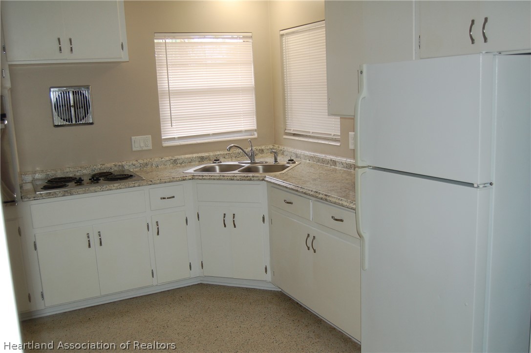 3029 West Verona Road Avon Park, FL 33825 - Photo 14 of 25 a kitchen with white cabinets and refrigerator