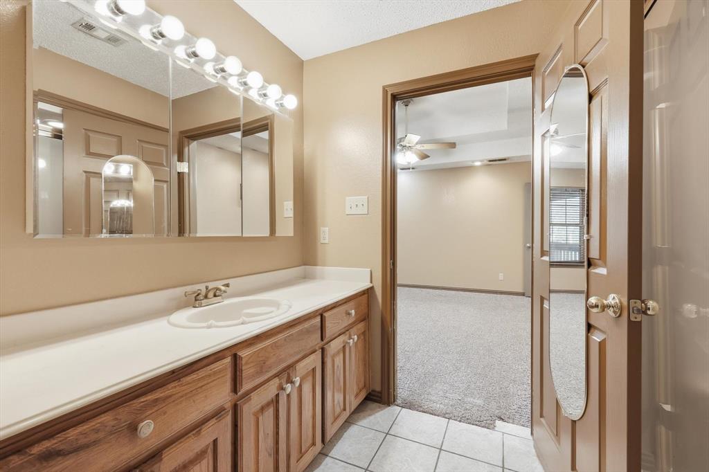 135 Private Road 2202 Decatur, TX 76234 - Photo 17 of 40 Bathroom featuring light colored carpet, vanity, light tile patterned floors, and a ceiling fan