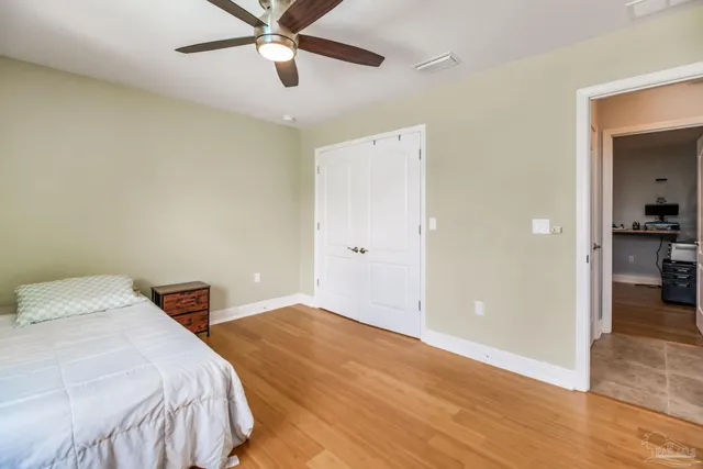 a bedroom with a bed and a ceiling fan