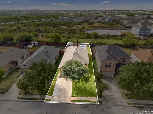 an aerial view of a house with a yard
