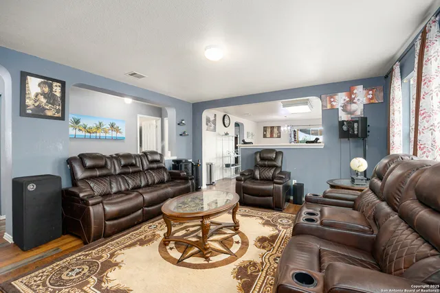 a living room with furniture and a wooden floor