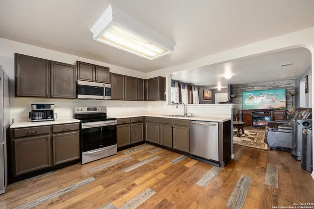 a kitchen with stainless steel appliances granite countertop a sink dishwasher stove top oven and refrigerator