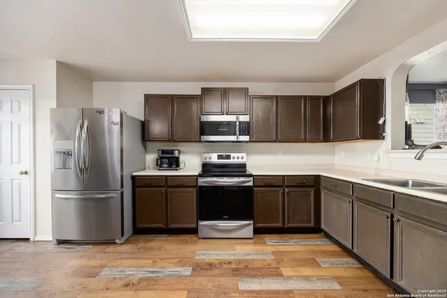 a kitchen with granite countertop a refrigerator and a sink