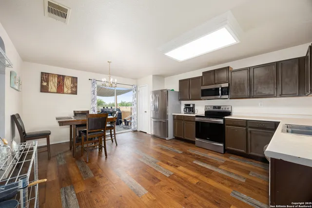 a kitchen with granite countertop furniture wooden floor and stainless steel appliances