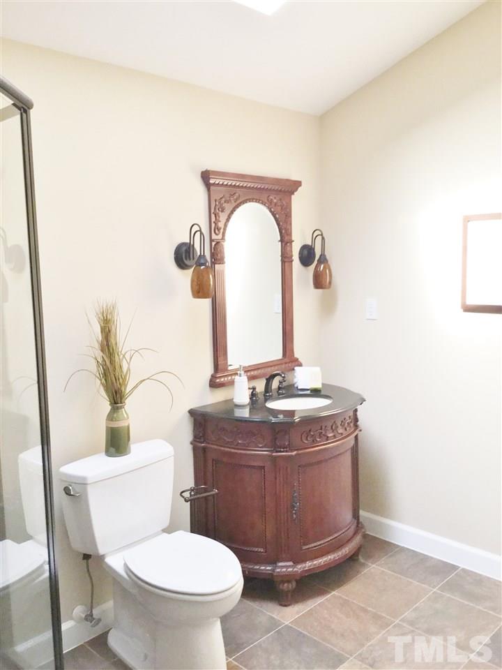 11604 Chipaway Court Raleigh, NC 27614 - Photo 15 of 25 a bathroom with a granite countertop toilet a sink and a mirror