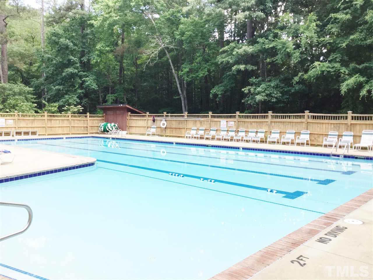 11604 Chipaway Court Raleigh, NC 27614 - Photo 20 of 25 a view of a swimming pool with a lawn chairs under an umbrella