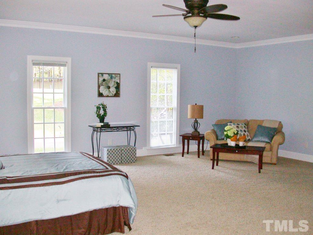 11604 Chipaway Court Raleigh, NC 27614 - Photo 7 of 25 a bedroom with a bed and a chandelier