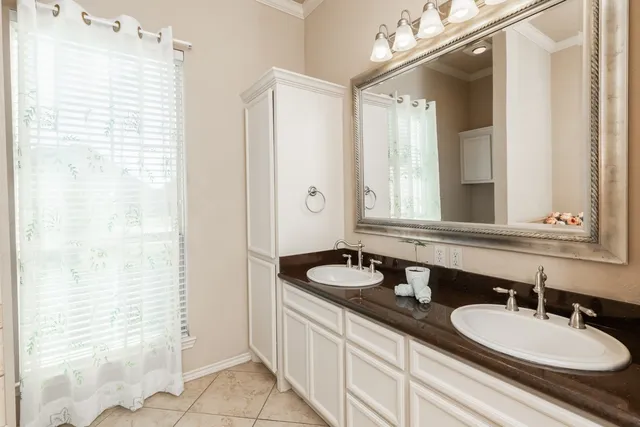 a bathroom with double vanity sinks and a mirror