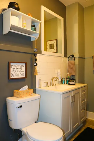 a bathroom with a granite countertop toilet sink and mirror