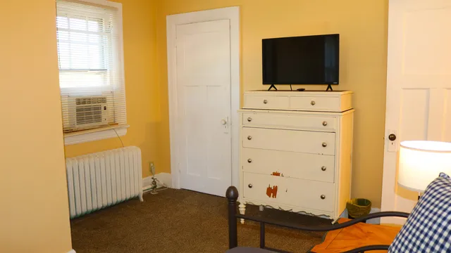 a view of a bedroom with bed and flat tv screen