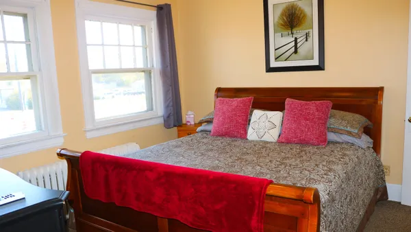 a bed sitting in a bedroom next to a window
