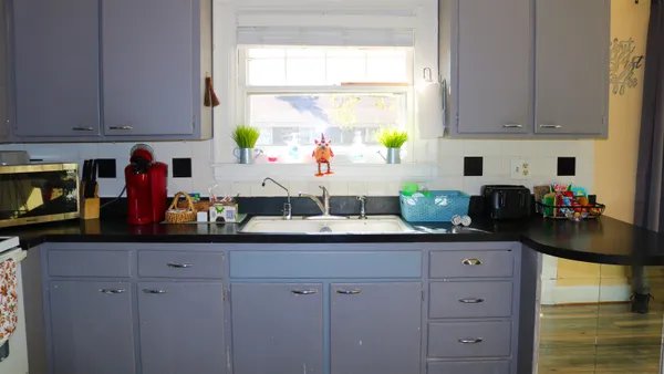 a kitchen with stainless steel appliances white cabinets and a window