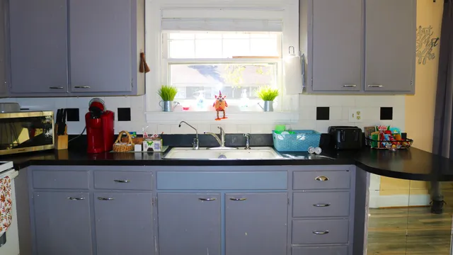 a kitchen with stainless steel appliances white cabinets and a window