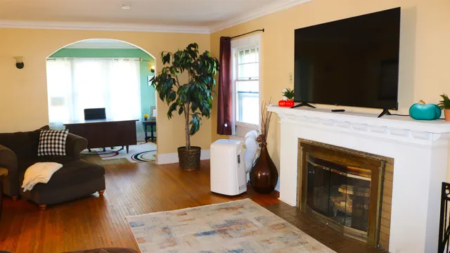 a living room with a couch a flat screen tv and a fireplace