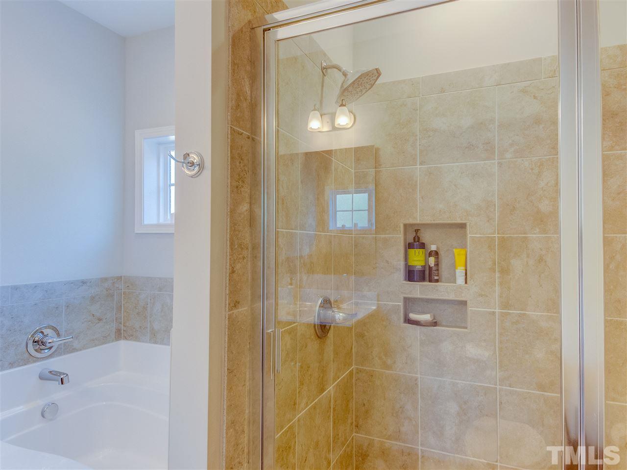 30 Mariners Point Way Garner, NC 27529 - Photo 15 of 25 Luxury Master Bath has tiled double shower, double marble sink counter, wood cabinets/vanity, garden with transom window above.