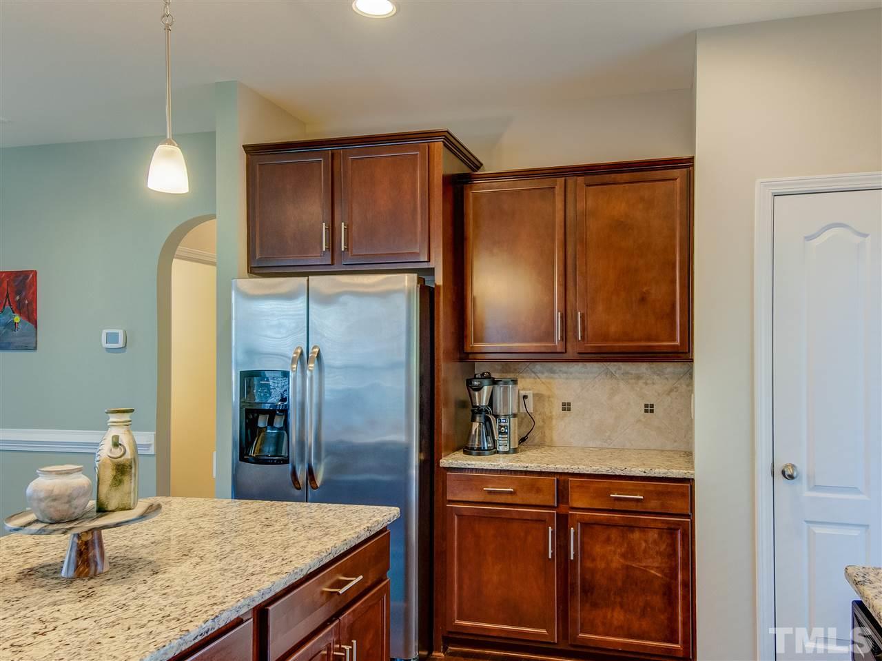 30 Mariners Point Way Garner, NC 27529 - Photo 9 of 25 Fantastic kitchen with center island. Quality wood cabinetry, granite counters, tile back splash, stainless steel appliances, recessed ceiling lighting, pendant lighting over island and hardwood floor. Glass door to screened porch.