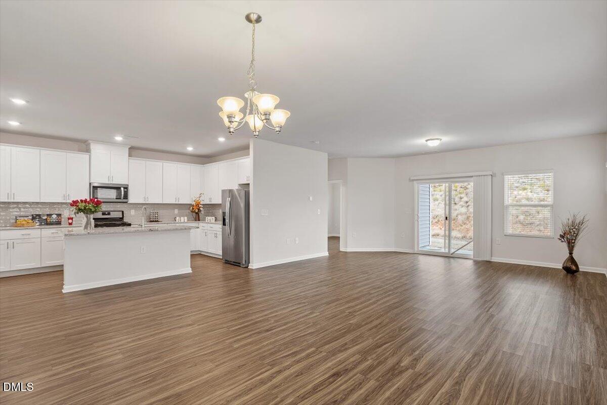 46 Coffee Tree Circle Clayton, NC 27527 - Photo 7 of 36 a view of an empty room and kitchen with wooden floor