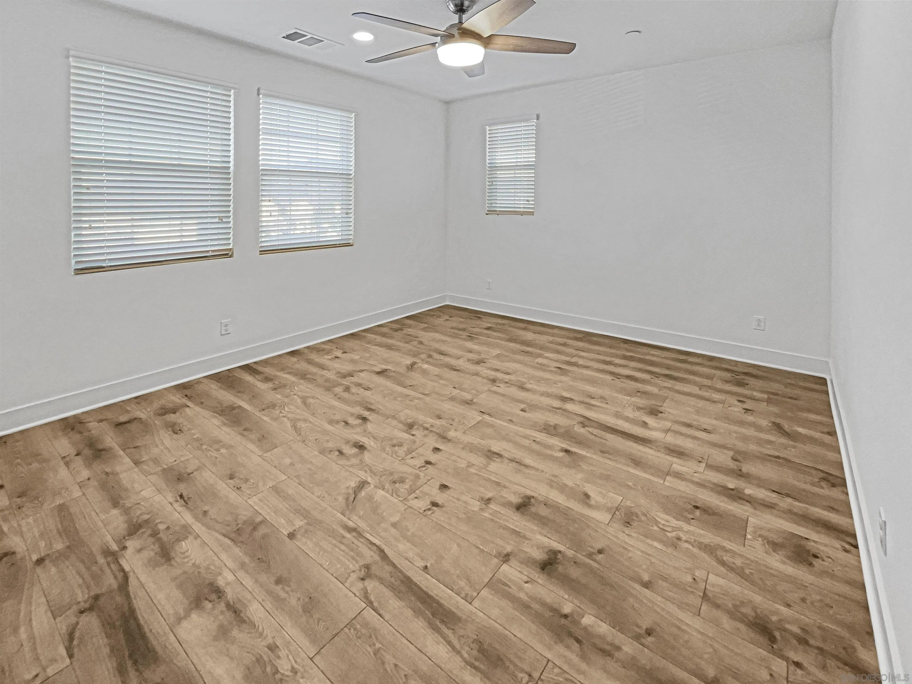35751 Garrano Lane Fallbrook, CA 92028 - Photo 16 of 28 an empty room with wooden floor and windows