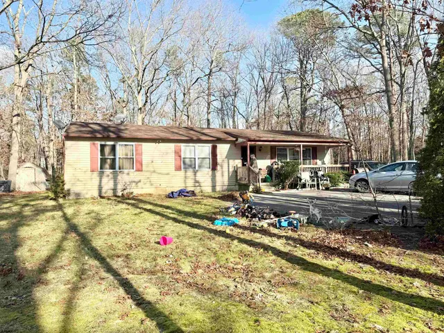 a view of a house with a big yard and large trees