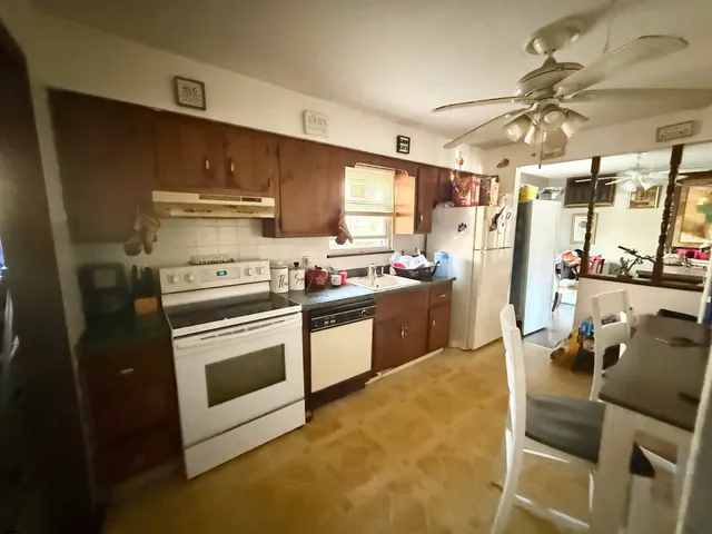 a kitchen with stainless steel appliances a stove a chimney a sink and cabinets