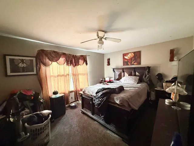 a bedroom with bed couch and window