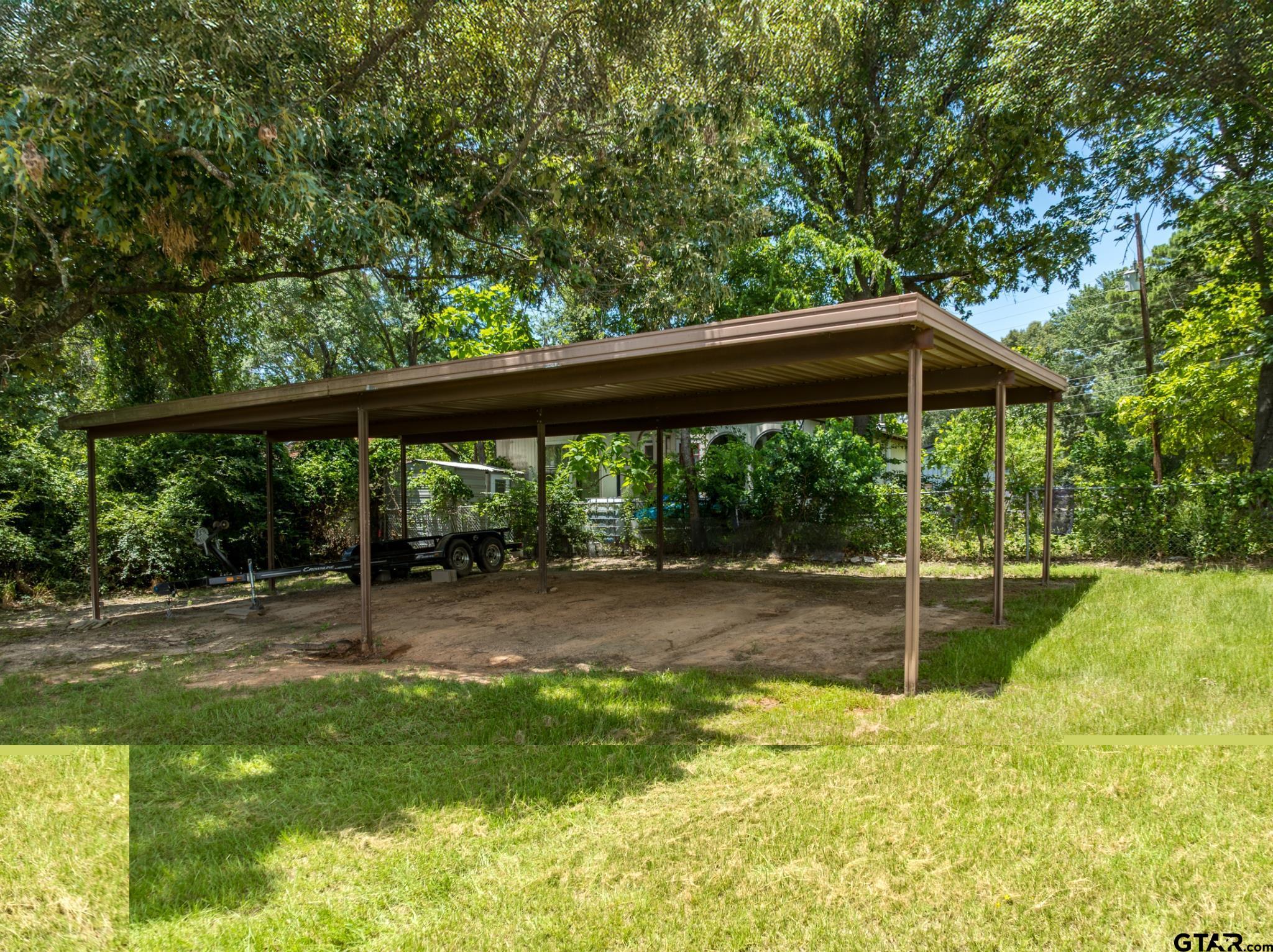 21516 Water Ridge Road Chandler, TX 75758 - Photo 28 of 48 a view of a backyard with table and chairs under an umbrella