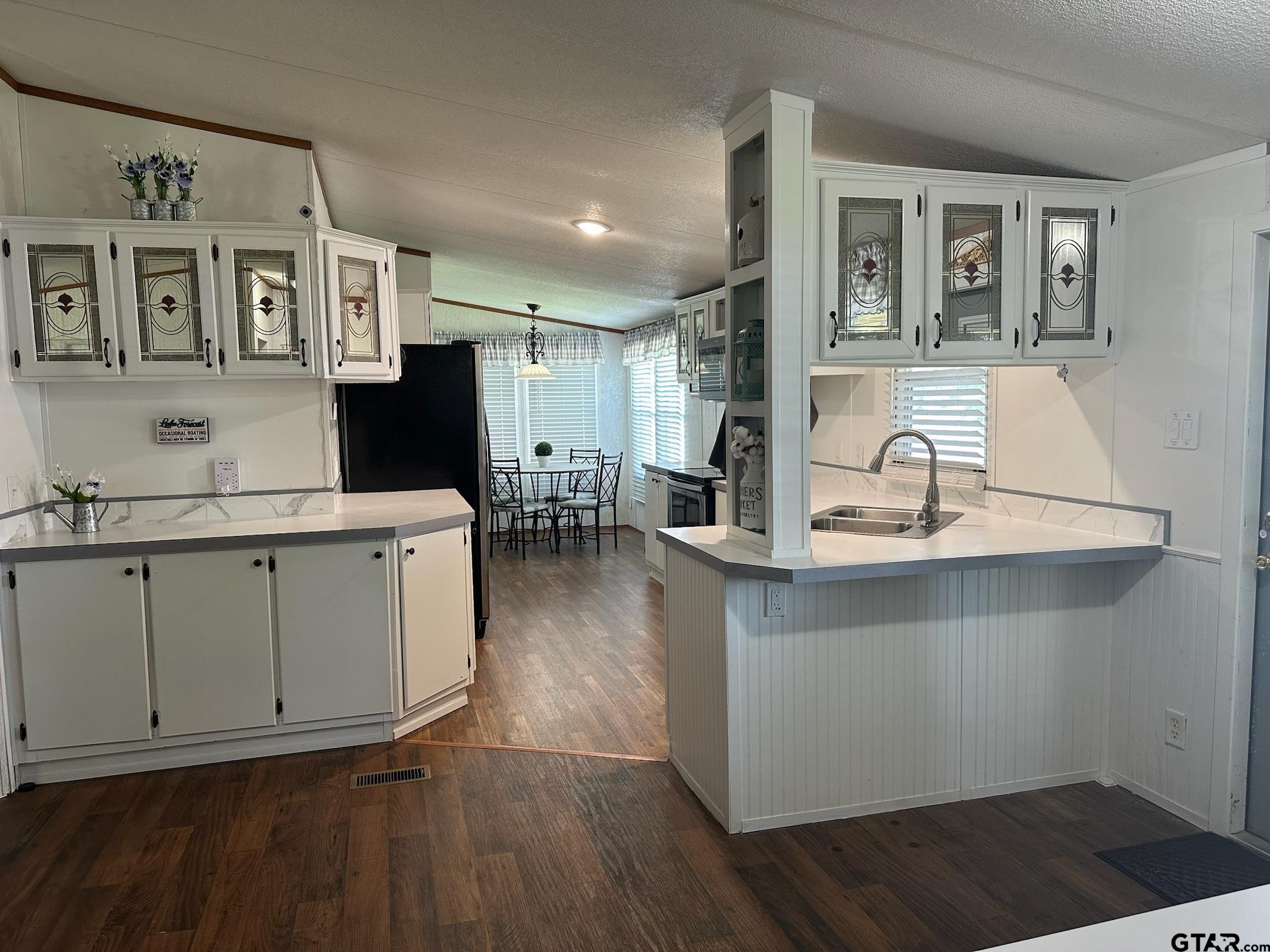 21516 Water Ridge Road Chandler, TX 75758 - Photo 6 of 48 a kitchen with a sink cabinets and wooden floor