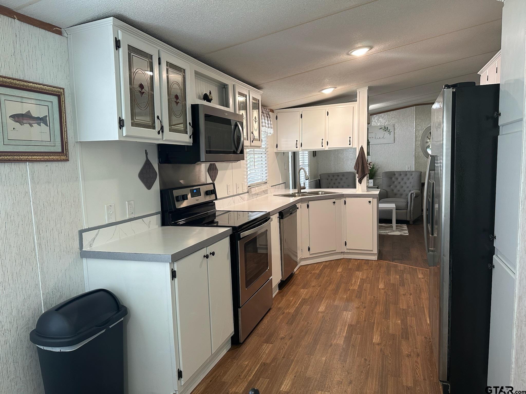 21516 Water Ridge Road Chandler, TX 75758 - Photo 8 of 48 a kitchen with a sink stainless steel appliances a refrigerator cabinets and a sink