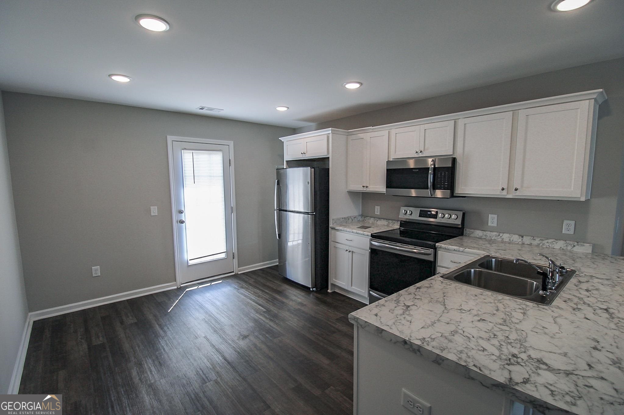 200 Evans Terrace Statesboro, GA 30458 - Photo 4 of 13 a kitchen with a sink a microwave a refrigerator and cabinets