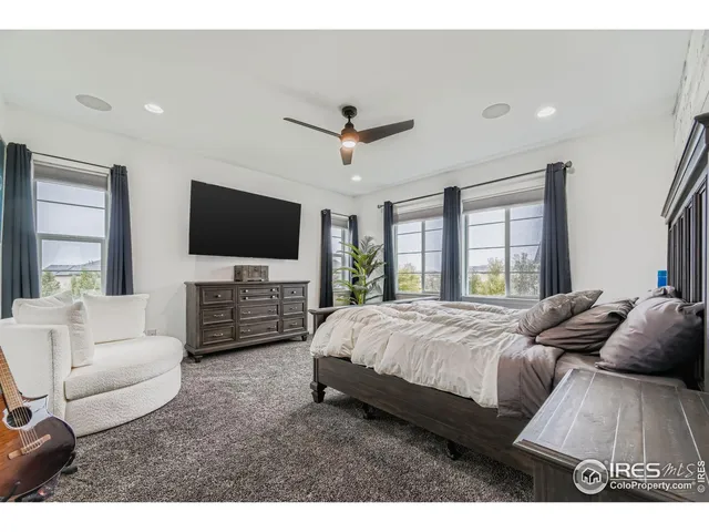 a spacious bedroom with bed and a flat screen tv