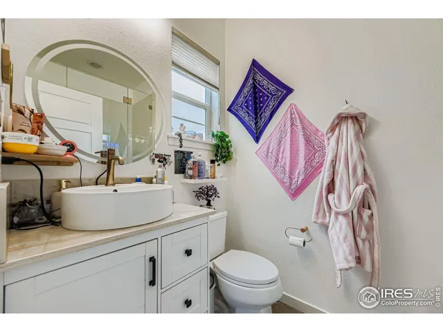 a bathroom with a sink mirror vanity and toilet