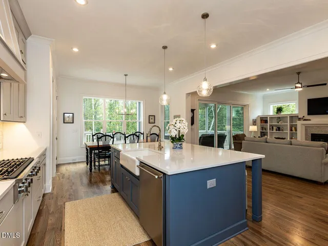 a kitchen with granite countertop a table chairs stove a sink and dishwasher