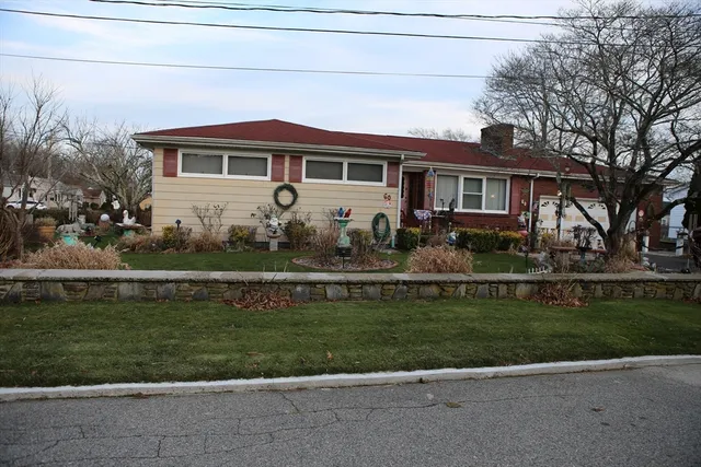 a front view of a house with a garden and trees