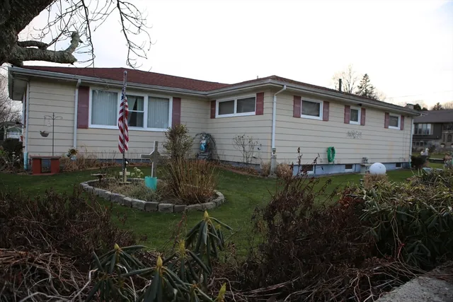 a view of house with a big yard and large trees
