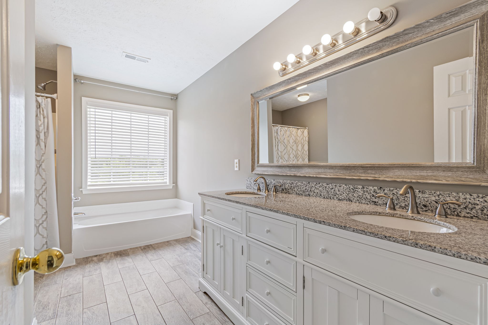 3137 Southall Road Franklin, TN 37064 - Photo 29 of 51 a bathroom with a granite countertop double vanity sink a mirror a bathtub and next to a window