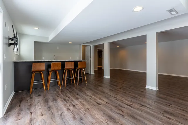 wooden floor with a table and chairs in it