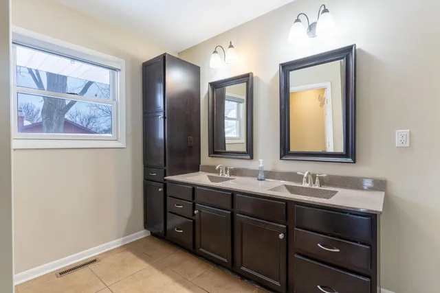 a bathroom with a double vanity sink and a mirror