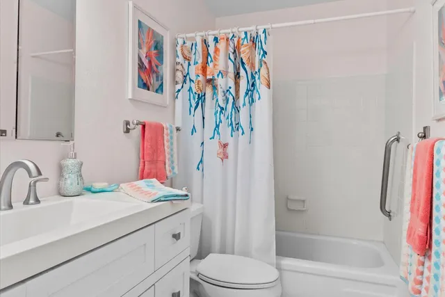 a bathroom with a sink vanity mirror and toilet