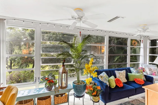 a living room filled with furniture and floor to ceiling windows