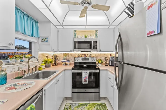 a kitchen with stainless steel appliances a stove a sink and a refrigerator