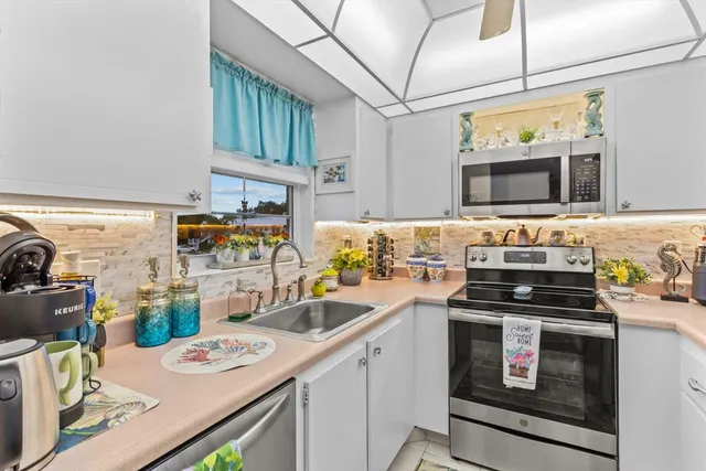 a kitchen with stainless steel appliances a stove a sink dishwasher and cabinets with wooden floor